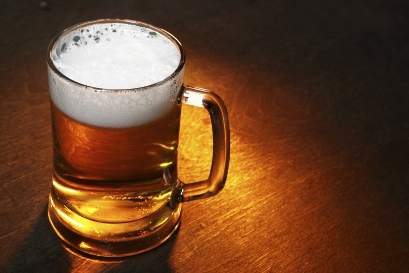 Mug of beer close up on wooden table